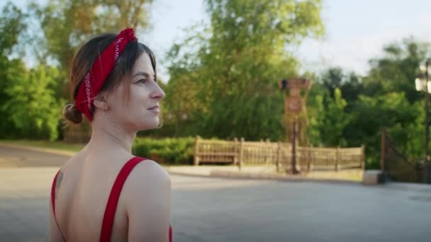 Χαρούμενο Κορίτσι Κόκκινο Φόρεμα Περπατώντας Στο Πάρκο Απολαμβάνοντας Δύση Του — Αρχείο Βίντεο