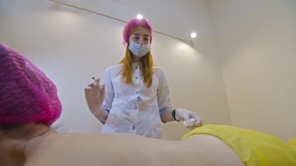 美容和注射的概念 美容学在诊所 一位戴着白色手套的经验丰富的美容师向女性背部注射含有必要活性成分的皮下注射 — 图库视频影像