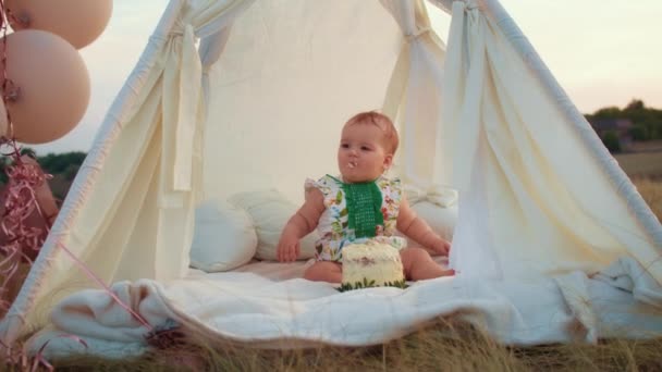 子供のライフスタイル ケーキとテントの中の日没の小さな子供の秋のフィールドで幸せな誕生日 写真家が誕生日を撮る 家族と赤ちゃんの喜び — ストック動画