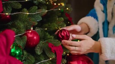 Noel Baba ve Bayan Noel Baba mutlu Noeller diliyor, hediyeler veriyor ve ağacı süslüyor.