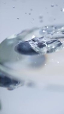 Beyaz Mavi Arkaplanda Su Sıçratan Yaban mersinli Süper Yavaş Film Çekimi. 300 fps hızla yüksek hızlı sinema kamerasında çekilmiştir.