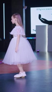 Podyumdaki kadın kıyafetlerinin moda tasarımı, renkli elbiseli güzel bir kızın lekelenmesi bir model şovunun podyumunda, dikey video