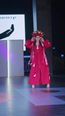 Podyumdaki kadın kıyafetlerinin moda tasarımı, renkli elbiseli güzel bir kızın lekelenmesi bir model şovunun podyumunda, dikey video