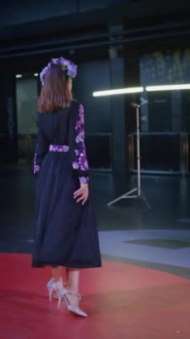 Podyumdaki kadın kıyafetlerinin moda tasarımı, renkli elbiseli güzel bir kızın lekelenmesi bir model şovunun podyumunda, dikey video