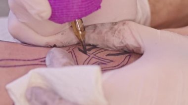 Profesyonel bir dövme sanatçısı, yetişkin bir adamın kolunda dövme yapar. Dövmede Rus savaş gemisine gidin yazıyor. Ukrayna ve Rusya arasındaki çatışma. Savaş 2022