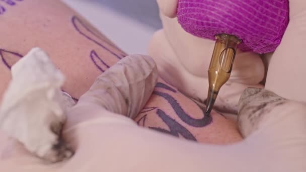 特写一个专业的纹身画家在一个成年男子的胳膊上做一个纹身 纹身说 去俄罗斯军舰 乌克兰和俄罗斯之间的冲突 2022年战争 — 图库视频影像