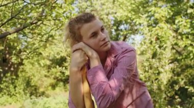 Bahçede, kadın bahçıvan güzel ve güneşli bir günde fidanlarıyla ilgilenmek için el arabasını kullanır. Bahçıvanlığın neşesini gösterir..