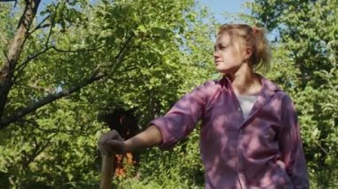 Bahçıvan kadın, tohumlarıyla bahçede çalışarak, organik yaşam tarzını sürdürerek ve bitkileriyle ilgilenerek güneşli bir günün tadını çıkarıyor..