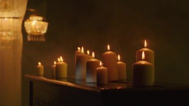 Cadı karanlık arka planda siyah mumlarla mistik bir ayin düzenliyor. Büyü ve putperestliği çağrıştırıyor. Yakın çekim, büyü ritüelinin şiddetini yakalar.