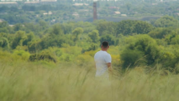 Mit Weit Aufgerissenen Armen Blickt Ein Mann Auf Einem Feld — Stockvideo
