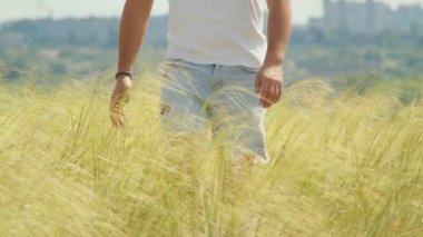 Bir adam kollarını tarlada kaldırır, batan güneşi kucaklar ve güzelliğin getirdiği özgürlük hissini..