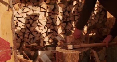 Odun yığınının yanında baltayla odun kıran biri. Sürdürülebilir yaşam ve kendi kendine yetme kavramı. Çevre blogu için tasarım, sürdürülebilir yaşam tarzı dergisi, DIY marangozluk rehberi.
