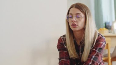 Gözlüklü, kareli gömlek giyen düşünceli bir kadın. Metin için bulanık arkaplan ve boşluk ile kapalı bir yaşam tarzı portresi.