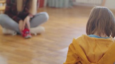 Genç bir çocuk ve bakıcısı, evlerini ısıtırken arabada oyuncaklarla eğleniyor, boş zamanlarının tadını çıkarıyor..