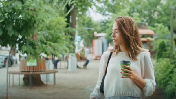 Nachdenkliche Frau Mit Regenschirm Und Kaffeetasse Auf Einer Straße Der — Stockvideo