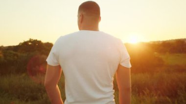 Beyaz gömlekli adam gün batımına bakıyor. Doğal manzaralı arka plan. Düşünce ve yalnızlık kavramı. Poster için tasarım, ilham kaynağı içeriği.