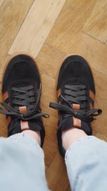 Kotlu siyah ve kahverengi spor ayakkabı giyen biri. Parke zemin zeminli yakın çekim. Günlük ayakkabı modası ve pankart için şehir yaşam tarzı konsepti, ayakkabı reklamı için tasarım