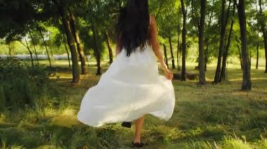 Ormanda yürüyen beyaz elbiseli bir kadın. Gizem, masal ve özgürlük kavramı. Kopyalama alanı olan arka plan.