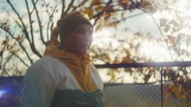 Sonbahar güneşinde dışarıda bere ve ceket giyen yaşlı bir adam. Bokeh efektli doğal doğa fotoğrafçılığı. Sonbahar sezonu ve açık hava yaşam tarzı konsepti.