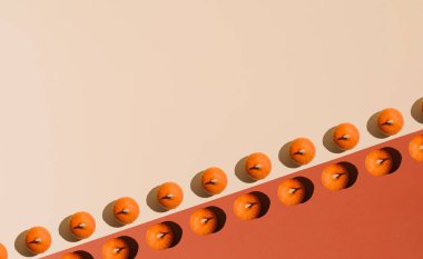 Cadılar Bayramı düz konum fikri, en düşük model kompozisyonu. Taze balkabağı turuncu ve bej arka planda. İyimser sonbahar konsepti.