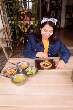 İspanyol Latin kadın Meksika yemeği yiyor, Meksika soslu biftek taco yiyor.