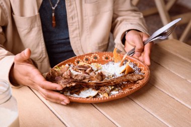 Meksika restoranında pirzola ile yeşil biber yiyen Latin bir adam.