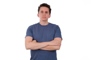 Beyaz arka planda kırmızı gömlekli bir adam kollarını kavuşturup ciddi bir jest yaparak gururunu, memnuniyetini ya da onayını gösteriyor.