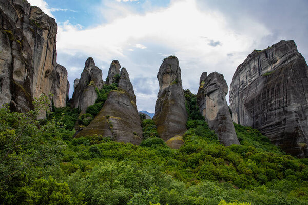 Величественные скалы Метеоры в Греции: Величественные скалы с ребристыми скалами посреди пышных зеленых холмов и потрясающих пейзажей