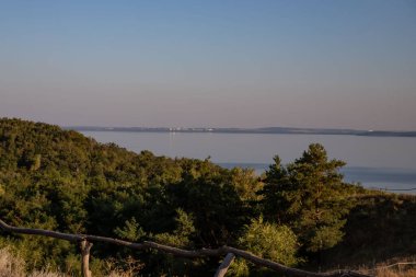 Etrafı Lush Trees, Grass ve Rocky Cliffs ile çevrili bir tepeden Serene Waterbody 'nin Hava Görüntüsü - Güzel Doğa Manzarası