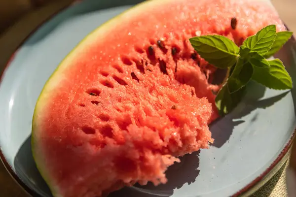 stock image Red Watermelon Flesh and Slices on a Blue Plate with a Green Mint Sprig  Fresh and Colorful Summer Treat