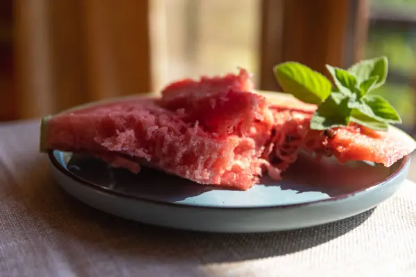 stock image Red Watermelon Flesh and Slices on a Blue Plate with a Green Mint Sprig  Fresh and Colorful Summer Treat