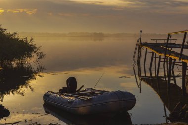 Gün batımında uzanan ahşap iskele, huzurlu doğa manzarası.