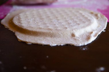 Ahşap bir oklava ile pembe bir hamurun üzerinde rulo hamuru: ev yapımı hamur köfteleri, fırın ürünleri veya pizza hazırlama