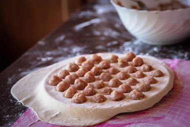 Ev yapımı hamur köfteleri pişirme süreci: yuvarlak bir kalıpta çiğ köfte, hamur işi, ulusal mutfak.