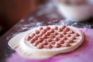 Ev yapımı hamur köfteleri pişirme süreci: yuvarlak bir kalıpta çiğ köfte, hamur işi, ulusal mutfak.