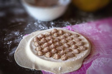 Ev yapımı hamur köfteleri pişirme süreci: yuvarlak bir kalıpta çiğ köfte, hamur işi, ulusal mutfak.
