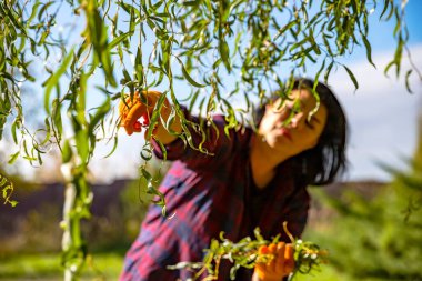 Bahçede Ağaç Budarken Telefonda Konuşan Genç Kadın
