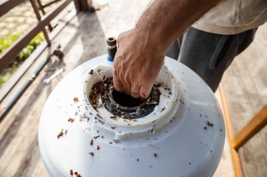 Temizlik ve Isıtma Elementi Değiştirme İçin Bir Kazan Parçalayan Adam