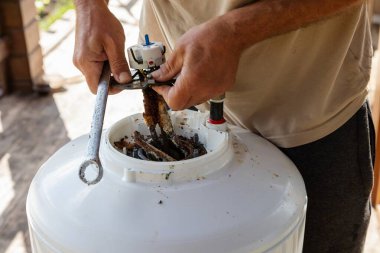 Temizlik ve Isıtma Elementi Değiştirme İçin Bir Kazan Parçalayan Adam