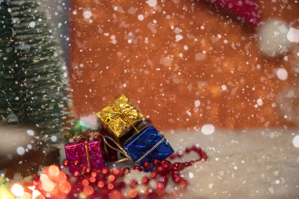 Renkli hediye kutuları, kar yağışı ve canlı bir arkaplanda yeşil bir Noel ağacı olan şenlikli Noel Sahnesi
