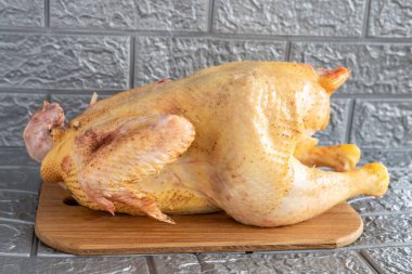 Fresh chicken with golden skin, ready for sale, close-up on a gray background clipart