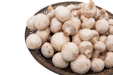 Dekoratif metal tepside taze şampiyon mantarları, beyaz arka planda izole edilmiş.