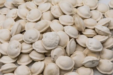 Beyaz arka planda donmuş ev yapımı hamur tatlısı, yemek pişirmek için geleneksel pelmeni