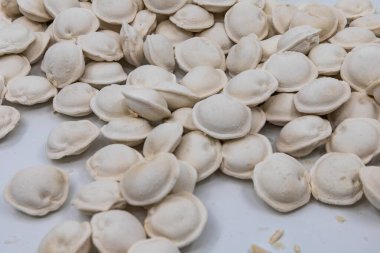 Beyaz arka planda donmuş ev yapımı hamur tatlısı, yemek pişirmek için geleneksel pelmeni