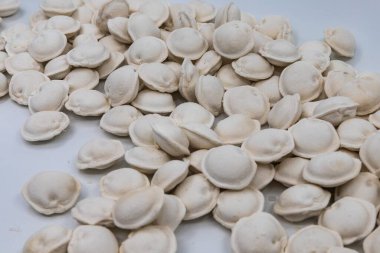Beyaz arka planda donmuş ev yapımı hamur tatlısı, yemek pişirmek için geleneksel pelmeni