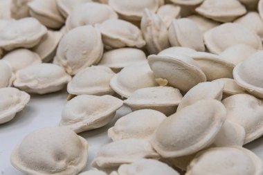 Beyaz arka planda donmuş ev yapımı hamur tatlısı, yemek pişirmek için geleneksel pelmeni