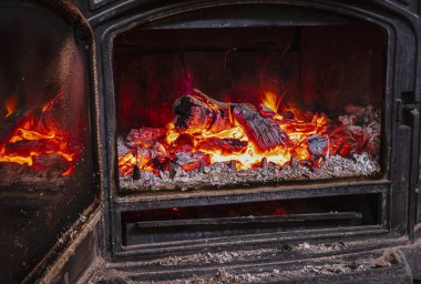 Parlak közleri ve kırmızı alevleri olan kırsal bir ocakta yakacak odun..