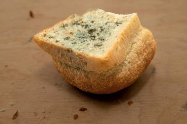 Ahşap bir yüzeyde küflü ekmek dilimi, bozulmuş gıda konsepti.