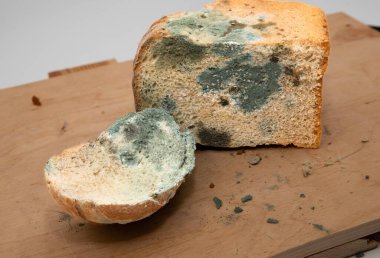 Ahşap bir yüzeyde küflü ekmek dilimi, bozulmuş gıda konsepti.