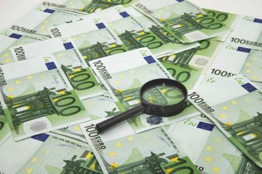 Beyaz zemin üzerinde büyüteç bulunan 100 euro banknot